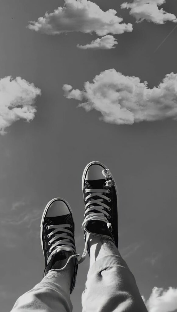 person lying with legs up on the background of the sky