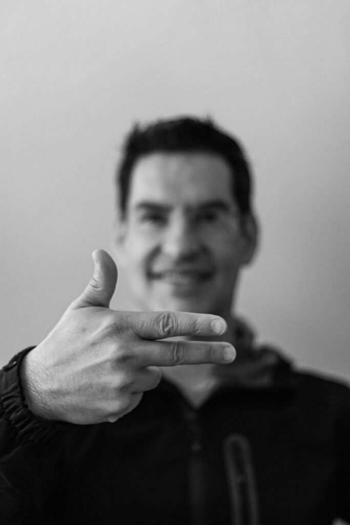 black and white photo of a man showing a sign with his hand