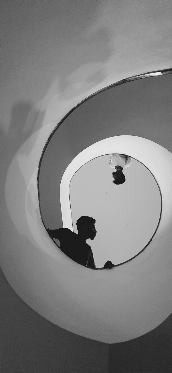 black and white photo of people on a spiral staircase